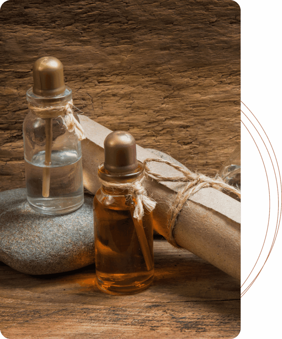 Essential oil bottles on rustic wooden background.