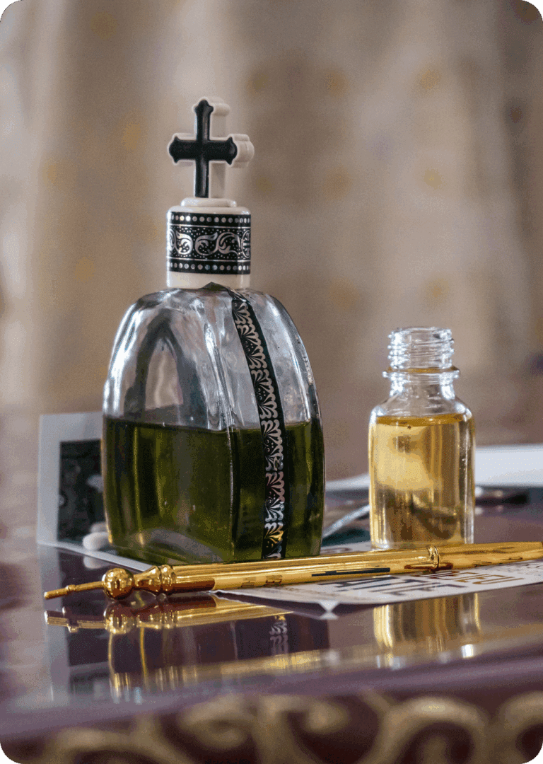 Bottles with cross on ornate table.